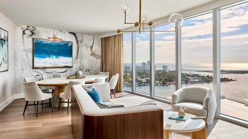 a living room with a table and chairs and a large window at Omni Fort Lauderdale Hotel in Fort Lauderdale