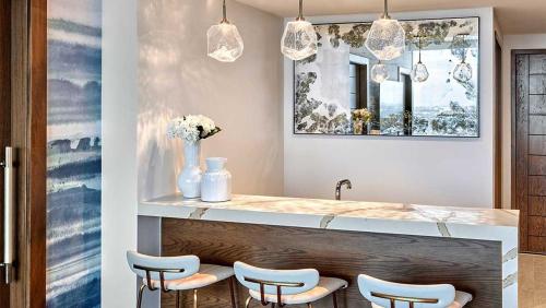 a kitchen with a counter with stools and a sink at Omni Fort Lauderdale Hotel in Fort Lauderdale