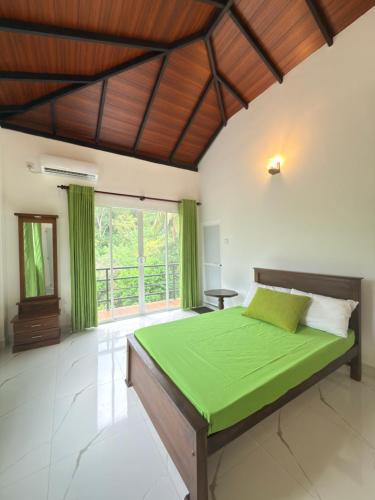 a bedroom with a large bed with green sheets at Hillcrest Bungalow in Matale