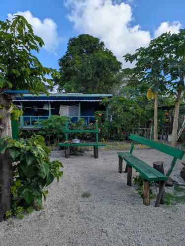 a park with two green benches and a building at Lamkail beach island bungalow in Lénakel
