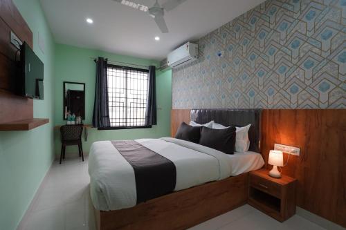 a bedroom with a large bed with a wooden headboard at Golden Comforts Banglore in Bangalore