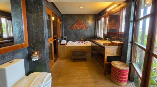 a bathroom with a sink and a bath tub at Birds and Bees Resort in Pattaya South
