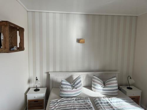 a bedroom with a bed with two pillows on it at lüttjeseeblick13 in Nordstrand