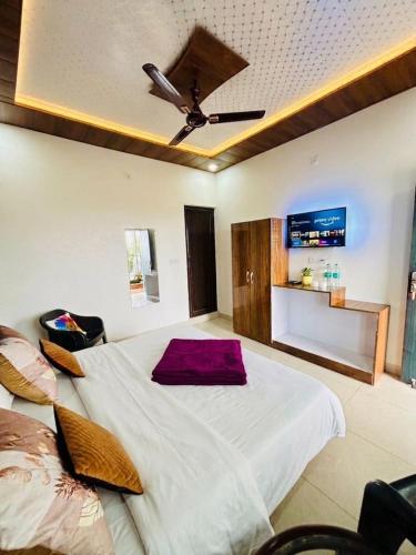 a bedroom with a large bed with a ceiling fan at Oliva by Quercus Oak Stays in Mussoorie