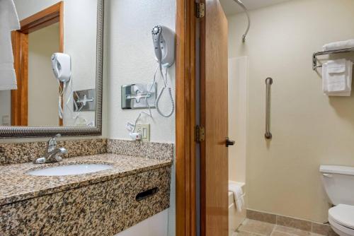 a bathroom with a sink and a toilet and a phone at Quality Inn Bloomington Near University in Bloomington