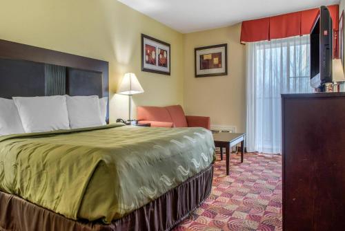 a hotel room with a bed and a television at Quality Inn Bloomington Near University in Bloomington