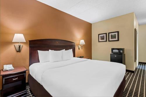 a hotel room with a large bed and a phone at Comfort Inn & Suites Somerset - New Brunswick in Somerset