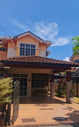 a house with a porch with a bench in front at Homestay Santai Bertam in Kepala Batas