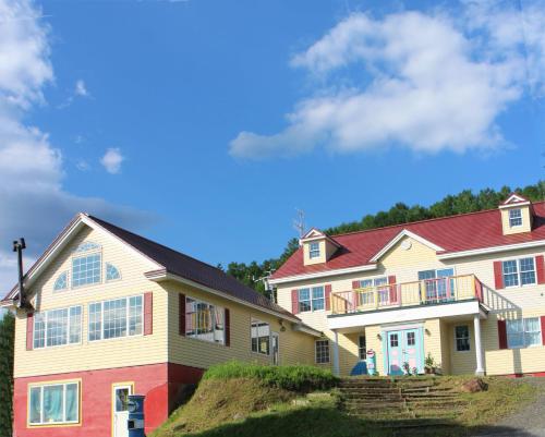 a large house with a red roof at Pension Hoshi Ni Negaiwo in Furano