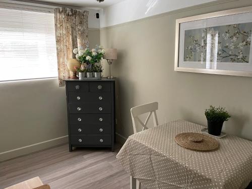 a room with a table and a dresser and a window at Oakwood in Fleet