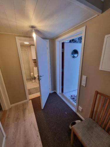 a hallway with a door to a bathroom with a shower at Sjöställe Gudö in Vendelsö