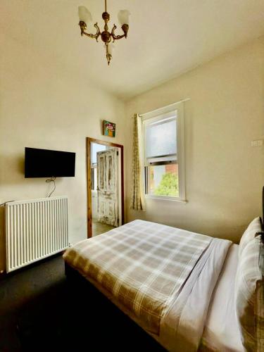 a bedroom with a bed and a window and a television at Royal Hotel Coonabarabran in Coonabarabran