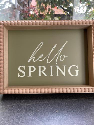 a picture of a hello spring sign in a window at Oakwood in Fleet