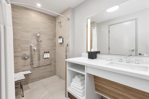 a bathroom with a sink and a shower at Wyndham Garden Anna in Anna