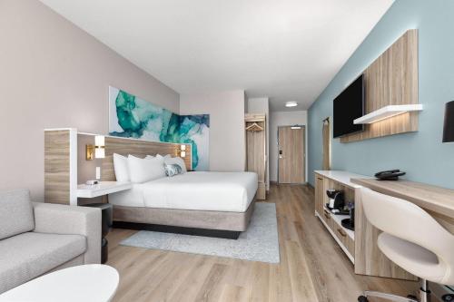 a hotel room with a bed and a couch at Wyndham Garden Anna in Anna