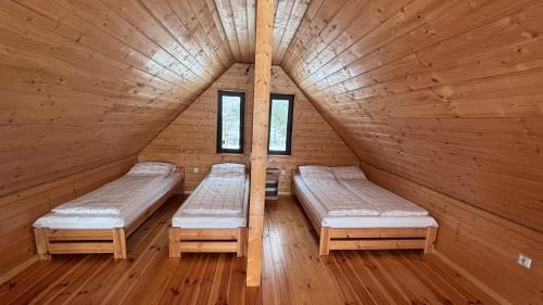a room with two beds in a wooden cabin at Domki u Ralfiego in Łuka