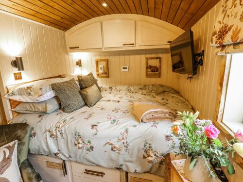 a bedroom with a large bed in a caravan at Twit Twoo Shepherds Hut in Louth