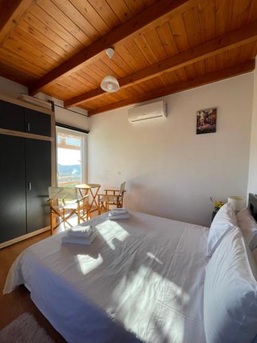 a bedroom with a large bed and a table and chairs at Tsitsinos maisonette house in Zekros