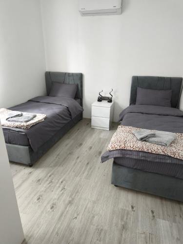 a bedroom with two beds and a wooden floor at Caesar Resort, Epictetus,Iskele, North Cyprus in Iskele