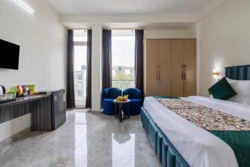 a hotel room with a bed and two blue chairs at Yashobhoomi Suites near Yashobhoomi Convention Centre in New Delhi