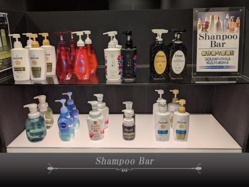 a shelf with a bunch of bottles of shampoo and soap at Hotel Crest Hirai (Adult Only) in Tokyo