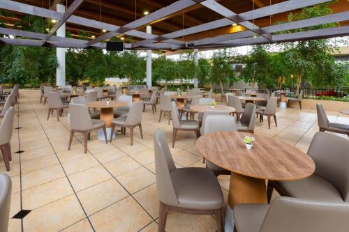 a restaurant with tables and chairs on a patio at Wyndham Garden Detroit Metro Airport in Romulus