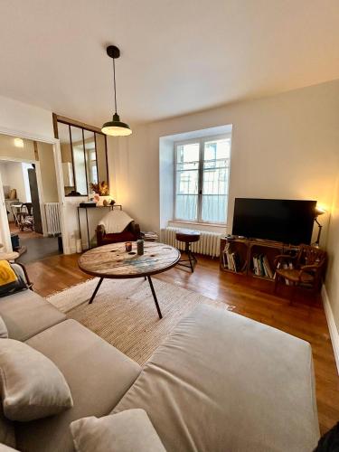 a living room with a couch and a table at Maison de campagne en plein centre de Senlis in Senlis