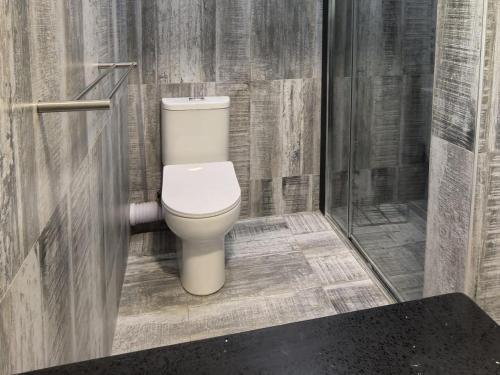 a bathroom with a white toilet in a stall at Happy Holiday Lodge in Meer en See