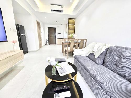 a living room with a couch and a table at Lloyd's Daily Suites - SOHO Residence, Bui Vien Walking Street, BenThanh Market & SG's Vibe in Ho Chi Minh City