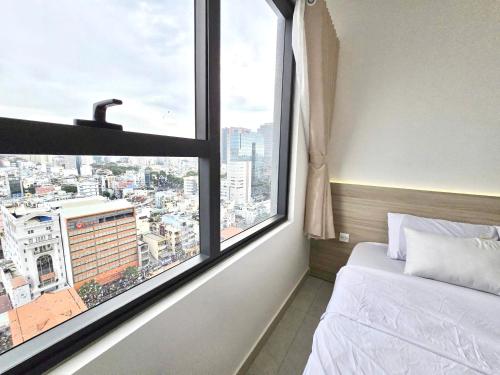 a bedroom with a bed and a large window at Lloyd's Daily Suites - SOHO Residence, Bui Vien Walking Street, BenThanh Market & SG's Vibe in Ho Chi Minh City