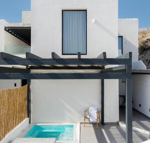 a house with a swimming pool on a roof at Blé Suites Santorini in Imerovigli