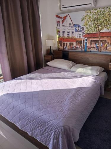 a large bed in a bedroom with a window at Cozy apartment with a sea view in Ban Bo Sai Klang