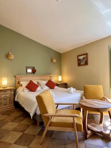 a bedroom with a bed and two chairs and a table at Colomba Hôtel Centre-Ville Historique in Bonifacio