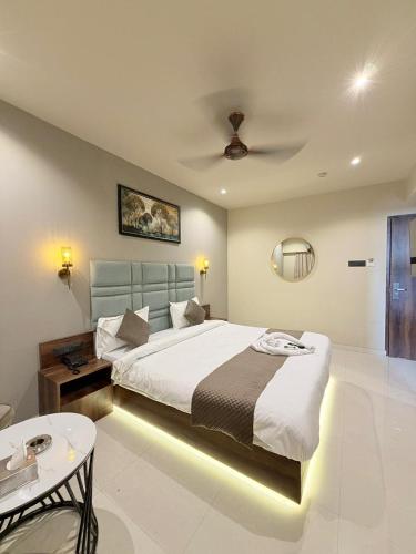 a bedroom with a large bed with a ceiling at Hotel Avenue Inn in Navi Mumbai