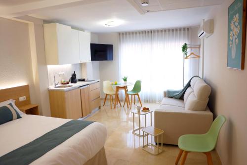 a hotel room with a bed and a kitchen and a table at Apartamentos VeraVibe in Caravaca de la Cruz