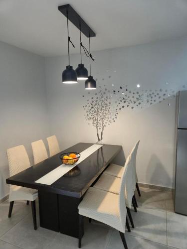 a dining room with a black table and chairs at Villa Larnaca Bay Resort in Oroklini