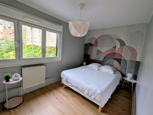 a bedroom with a bed with a painting on the wall at Ma Casa in Boulogne-sur-Mer
