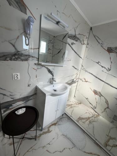 a white bathroom with a sink and a mirror at ElGringo Clisura Dunarii in Moldova Nouă