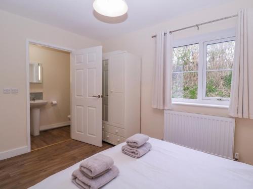 a bedroom with a bed with towels on it at Country Cottage in Brecon