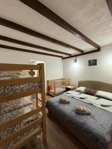 a bedroom with two bunk beds and a crib at Vila KTM Lisine in Despotovac