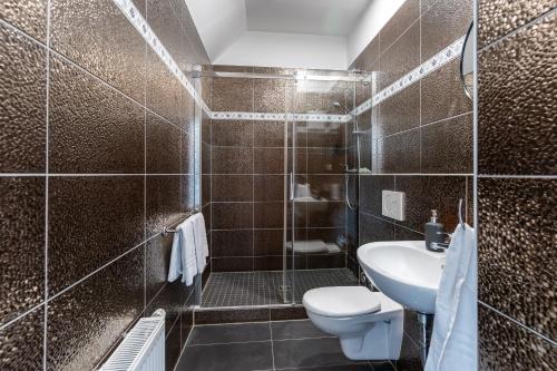 a brown tiled bathroom with a toilet and a sink at Jotica Colonia in Cologne