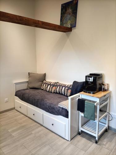 a bed in a room with a desk with a computer on it at Maisonnette étape équestre in Nogent-lʼArtaud