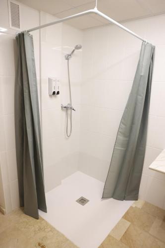 a shower with a shower curtain in a bathroom at Apartamentos VeraVibe in Caravaca de la Cruz