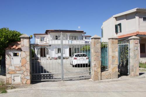 a gate to a house with a white car behind it at Casa vacanze Teresa in Capo Vaticano