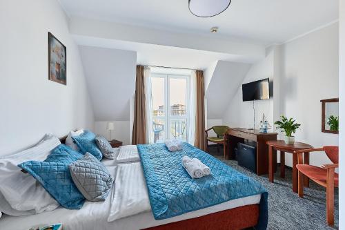 a bedroom with a bed with blue pillows and a desk at Willa Wodnik in Świnoujście