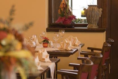 a dining room with tables and chairs with wine glasses at Berg-Gasthof Honigbrunnen in Löbau