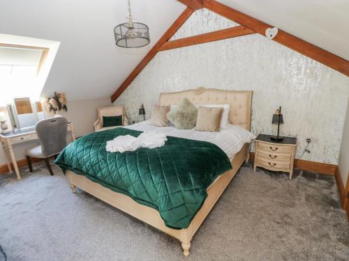 a bedroom with a large bed with a green blanket at Rose Apartment - Gower in Swansea