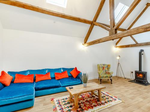 a blue couch in a living room with a table at The Granary - Uk38980 in Llandyssil