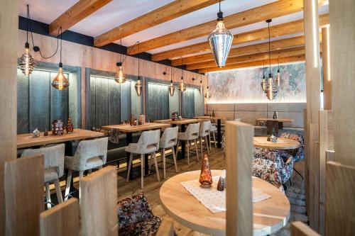 a restaurant with wooden tables and chairs and lights at Hotel Trattnig in Döbriach