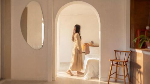 a woman in a dress walking through an archway at gyeongju planb pet pension in Gyeongju